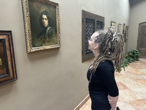 Carol D'Arcy viewing a painting in the gallery at David Leffel and Sherrie McGraw's home, Arroyo Seco, New Mexico 2023.